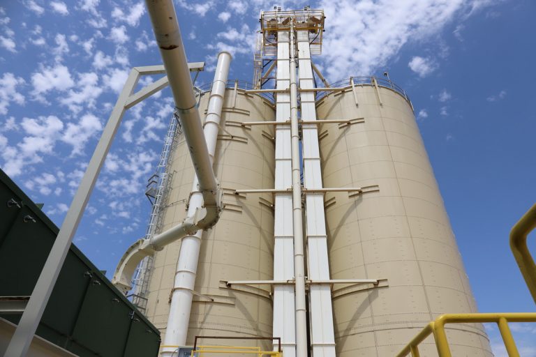 Dry bulk frac sand storage tanks with bucket elevators